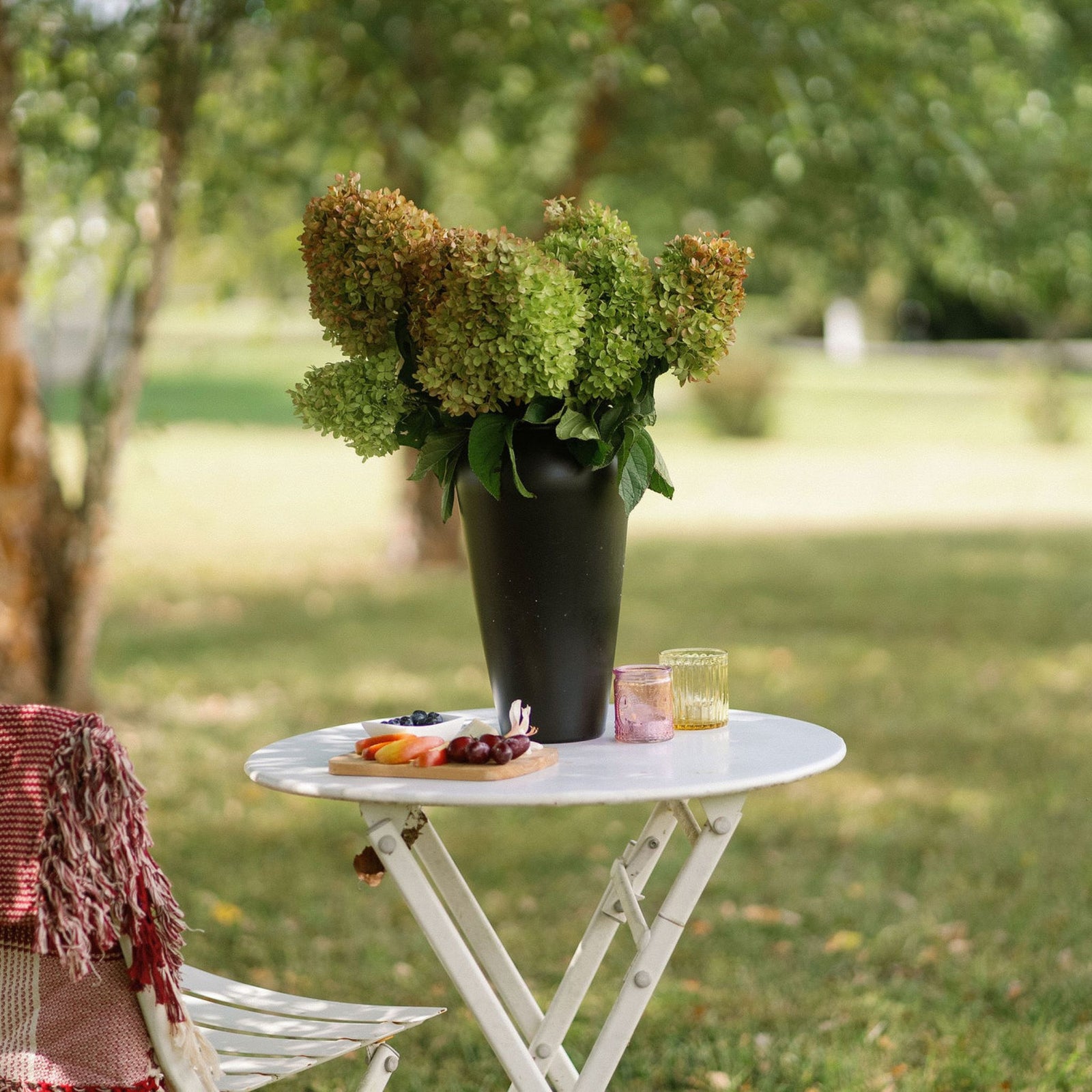 Black classic vase on table with picnic setup